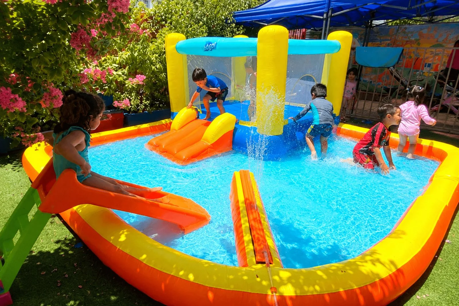 Niños y niñas disfrutando juegos de agua durante el Taller de Verano Rukantú